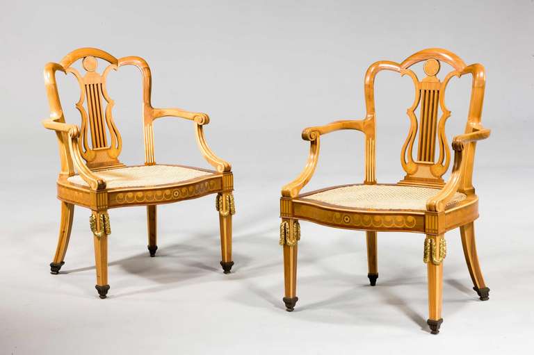 A good pair of golden mahogany and gilt bronze-mounted elbow chairs with contrasting mahogany and boxwood inlays, the front stiles with Vitruvian scroll inlays, the supports with finely cast gilt bronze swags.

Literature
See Helena Hayward and Pat