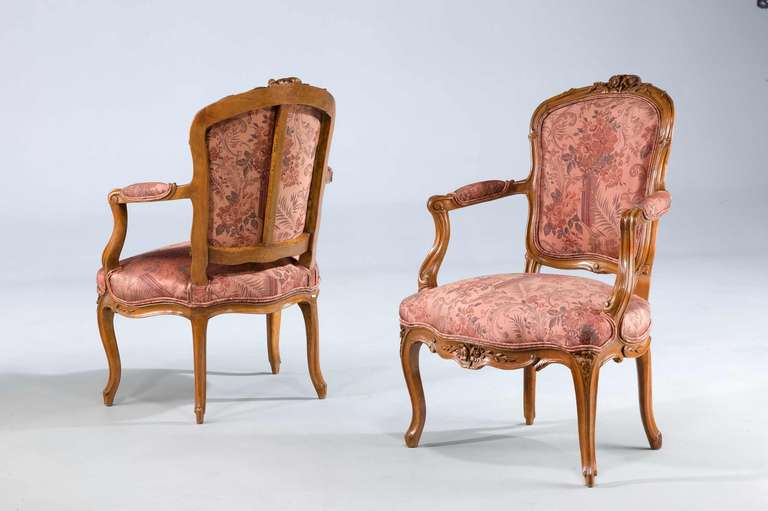 A good pair of 18th century Louis XV period beech Fauteuils signed TBA, the backs with well carved floral decoration with strongly shaped serpentine front rails.

