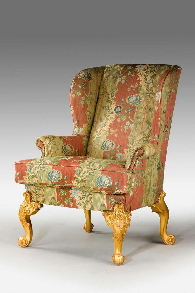 A finely carved 19th century giltwood wing chair of mid-18th century design with very pronounced cabriole legs to all four supports.

Provenance:
An 18th or 19th century wing chair is an easy chair or club chair with "wings" mounted to