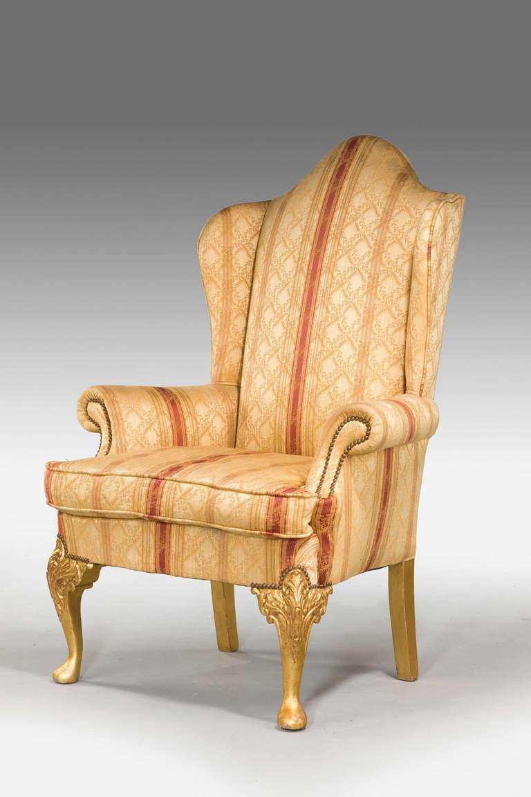 A well carved 19th century giltwood wing chair with high shaped back of mid-18th century design with water gilt decoration.

Provenance:
An 18th or 19th century wing chair is an easy chair or club chair with 