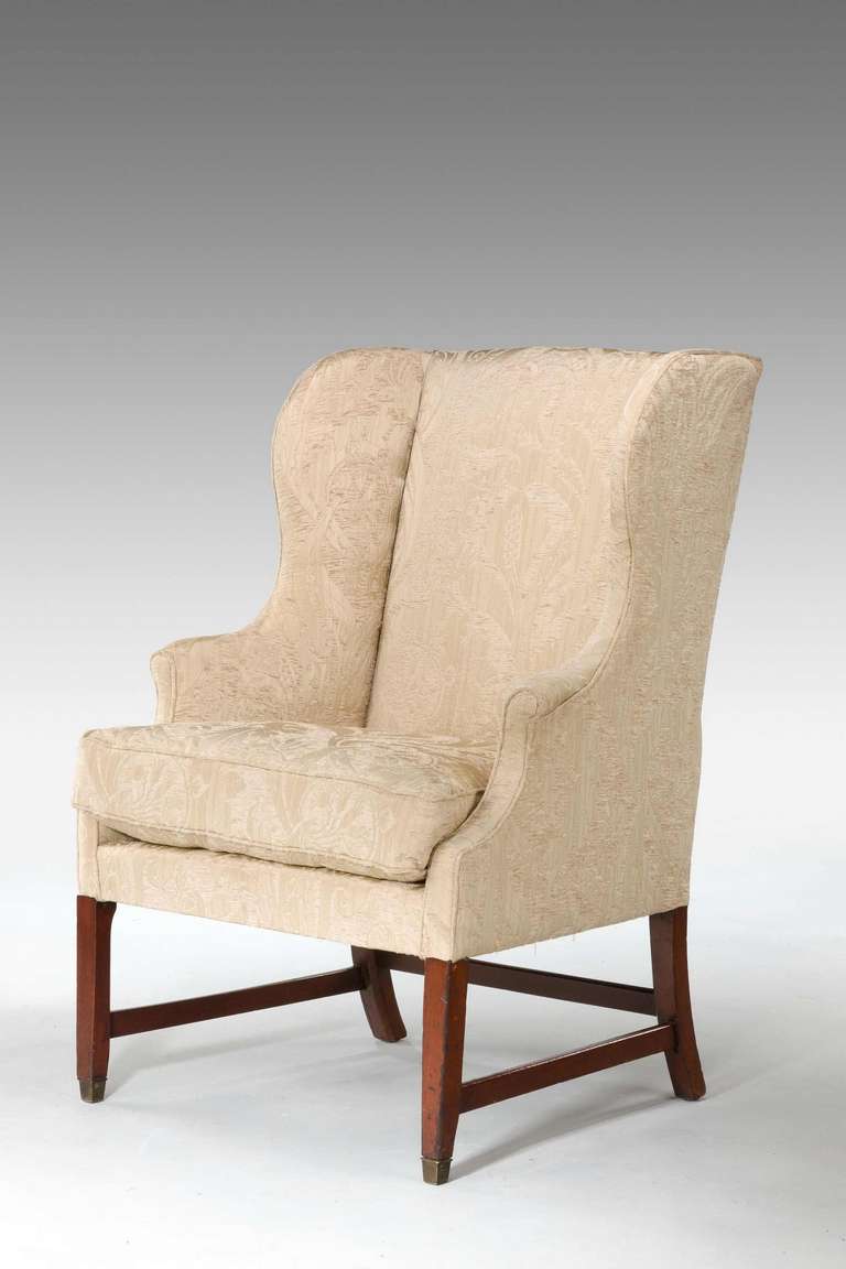 George III period mahogany framed wing chair on square supports with cross stretchers.

