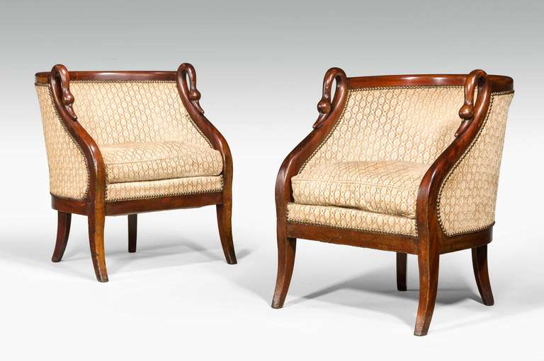 A pair of French mahogany framed armchairs with simulated swan's neck uprights, very well figured timber on gentle sabre supports.

RR.