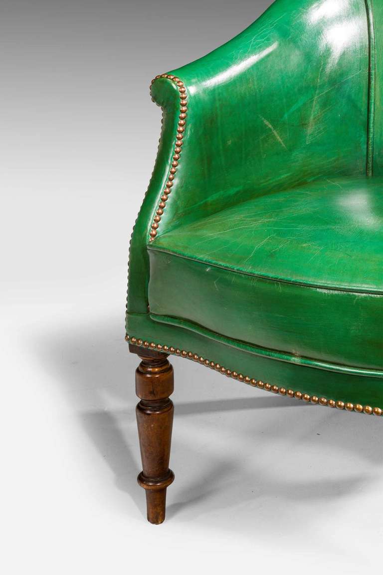 A good Regency period green leather library chair, covered in the finest hand dyed and finished cowhide, turned front supports, the back incorporating an unusual adjustable support.