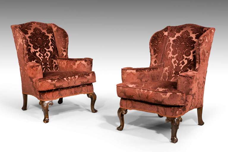 A substantial and attractive pair of mahogany frame wing chairs of early George III design, good curved arms and shaped wings, the cabriole supports well carved, now upholstered in a fine cut velvet fabric.

Provenance:
An 18th or 19th century wing