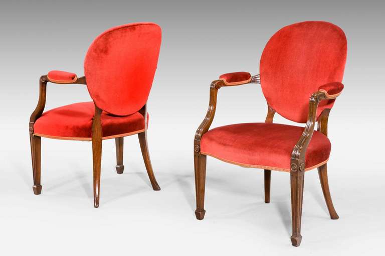 Pair of mahogany framed elbow chairs of George III design, incised and reeded detail to the supports and armrests, square tapering supports terminating in bock feet, mid-20th century.