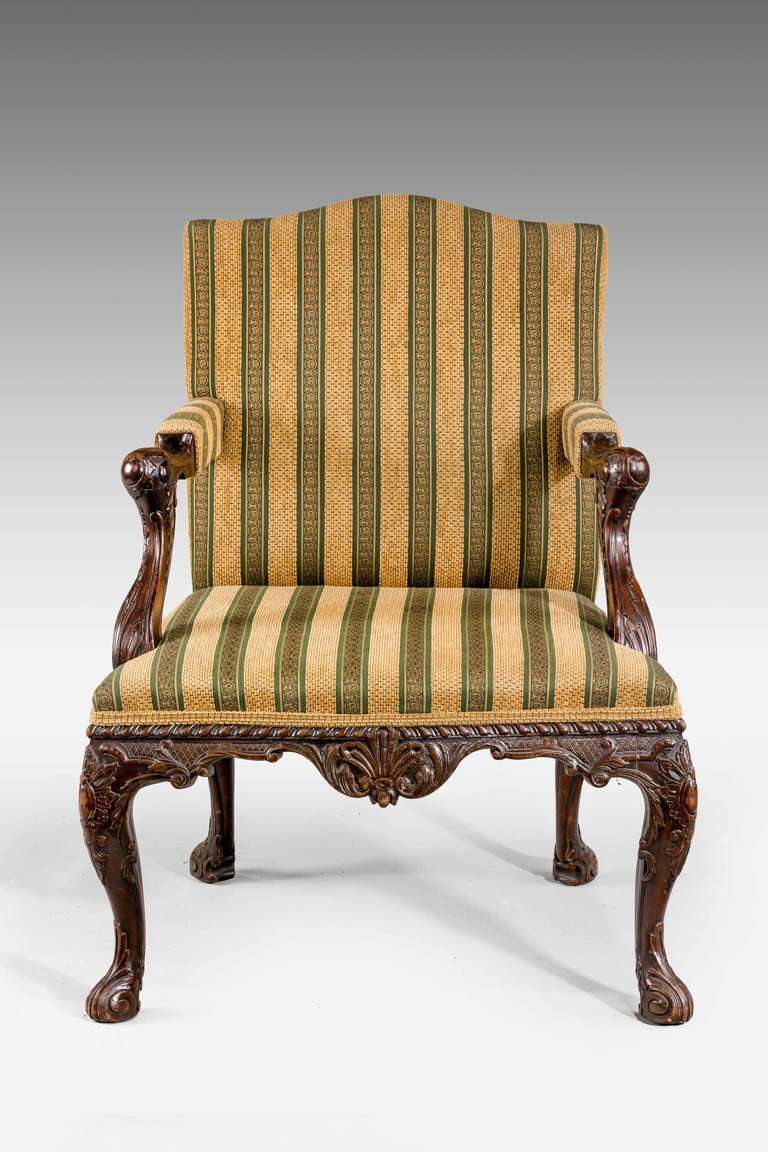 A very well carved 19th century mahogany Gainsborough chair, the arms with cabochon terminals and acanthus leaves, the rails with cross-hatched decoration and elaborately carved cabriole supports terminating in a 'French' foot. 

Provenance:
A