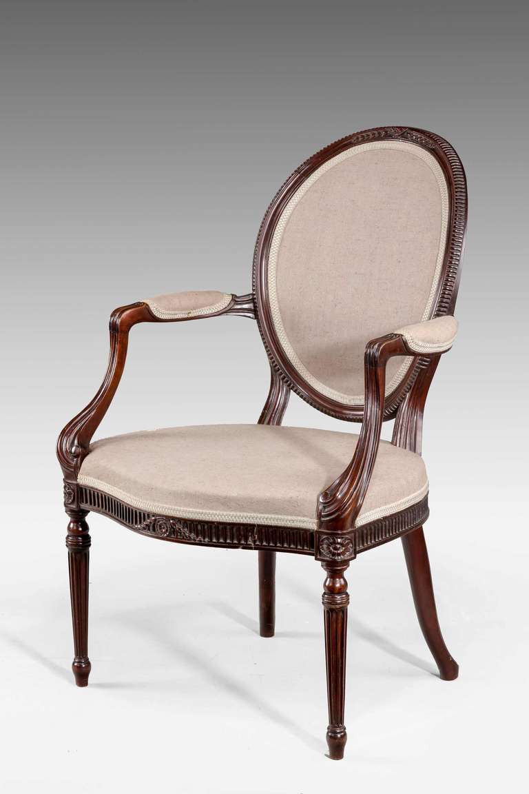 An elegant mahogany framed Armchair of George III design, the oval back with a continuously carved ribbed border and with harebells. Fine swept arms and the front rail with incised carving and harebells emanating from a central paterae.