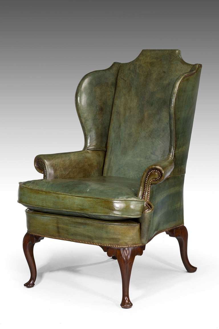 Une chaise d'aile à pieds cabriole en acajou:: de style George III précoce. Le rembourrage est en cuir de vachette teintée à la main de qualité supérieure:: avec des bords très serrés. 

Provenance
Un fauteuil à oreilles du XVIIIe ou du XIXe siècle