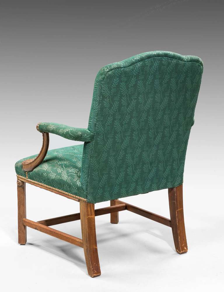 Chippendale design mahogany 'Gainsborough' armchair, the arms supports with deep incised carving, the uprights with blind fret edges joined by square stretchers.

RR.