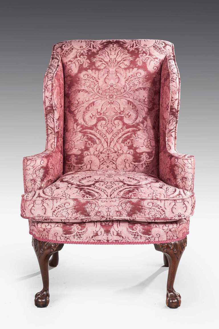 An attractive mahogany framed wing chair of mid-18th century design, the cabriole supports with carved knees terminating in claw and ball feet, covered in Gainsborough silk fabric.

Provenance:
An 18th or 19th century wing chair is an easy chair