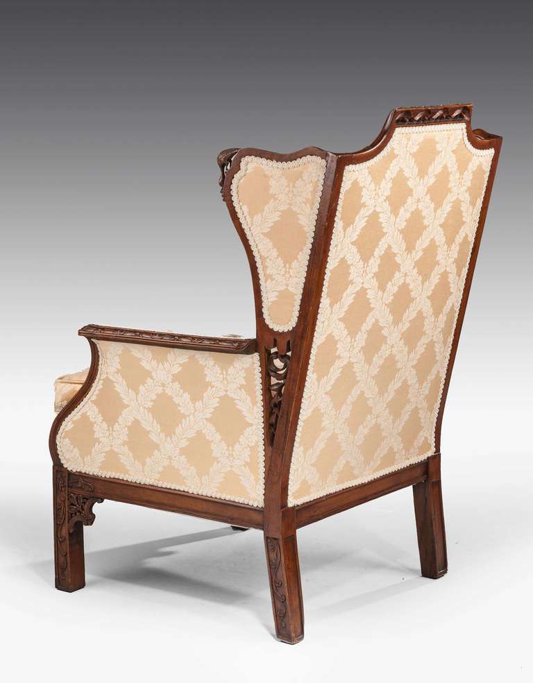An attractive mahogany framed Library Chair, the continuous wooden frame carved with foliage, the top of the upper section with a delicately pierced border, the supports with inset carving and pierced carved brackets.

RR