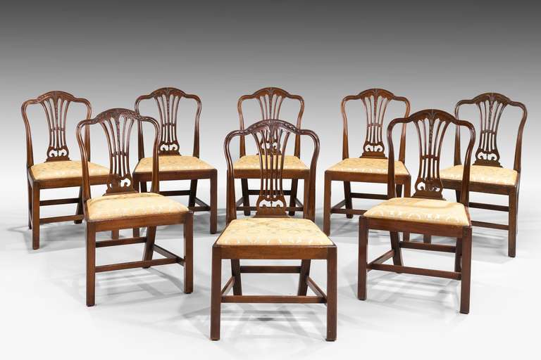 Set of eight George III mahogany chairs with gentle camel shaped backs, the splats with wheat-ear and hair bell carving.

