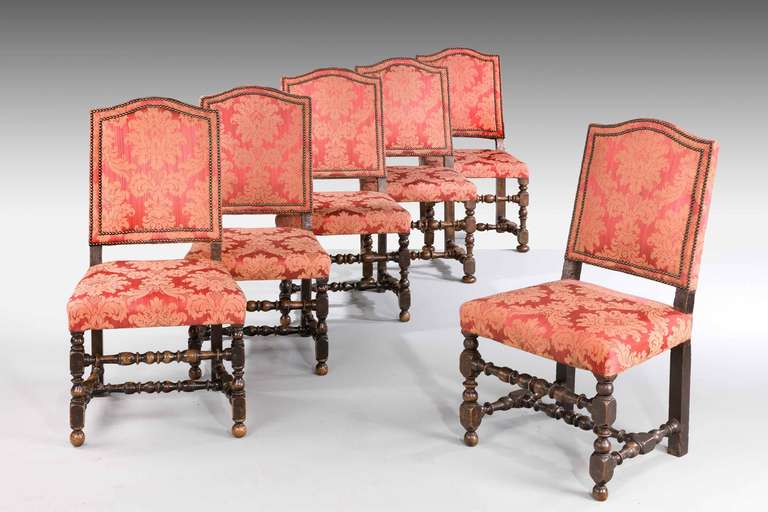Set of six 17th century style walnut chairs with finely turned supports and cross stretchers, the backs double studded.

