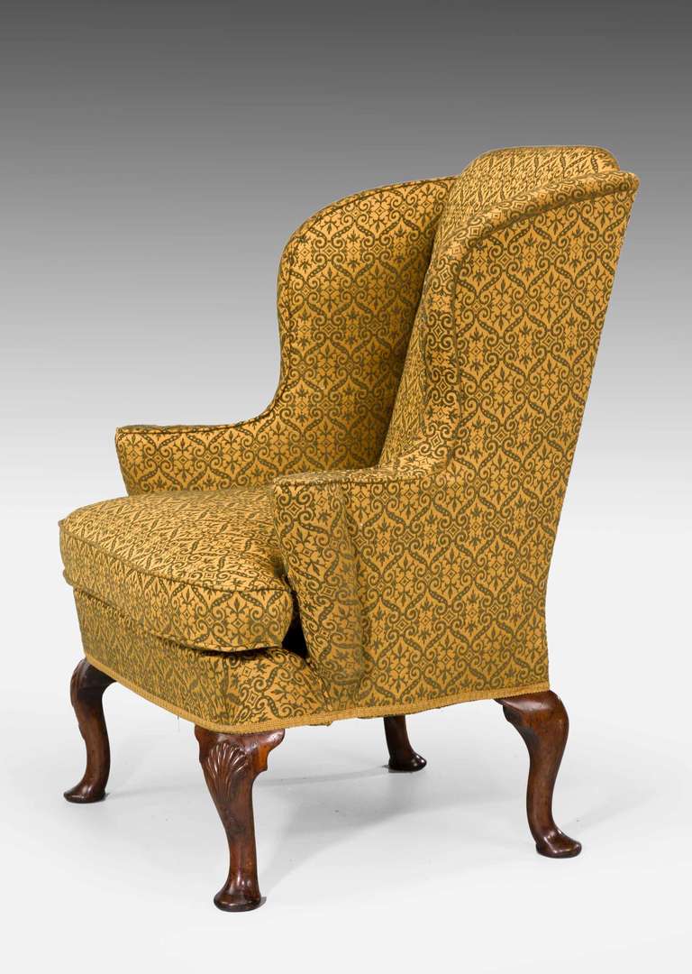 George I period walnut wing chair, the short cabriole supports with fan highlighted carving on an attractive tight design.