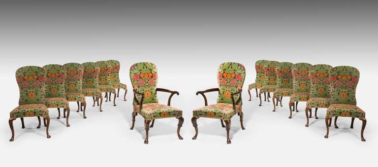 Fine Set of Fourteen ( Twelve plus two ) walnut Dining Chairs, the supports with bandage decoration and well shaped flared back supports.Twelve side chairs circa 1730, two armchairs circa 1900.