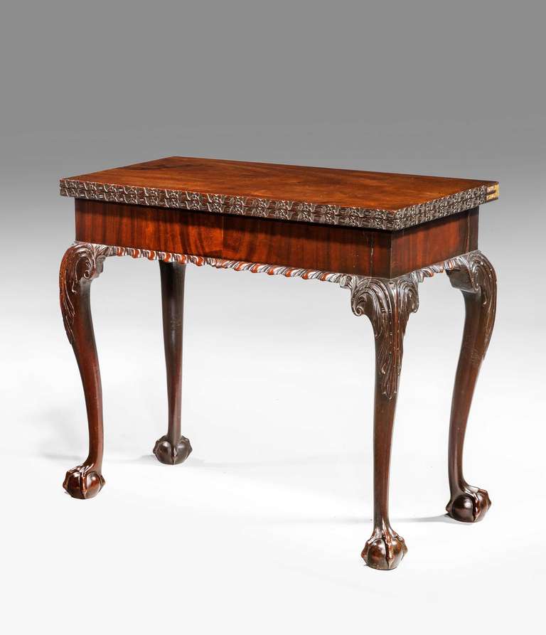 A Chippendale period mahogany tea table with very well figured veneers framed within crisply carved borders with gate leg action and on well carved cabriole supports.

