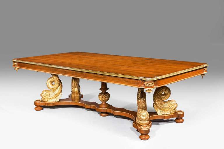 A rare mahogany and parcel-gilt and gilt bronze 19th century centre table with very well carved gilded dolphin supports on a shape platform base. This table can be used as a dining table comfortably accommodating up to ten chairs.