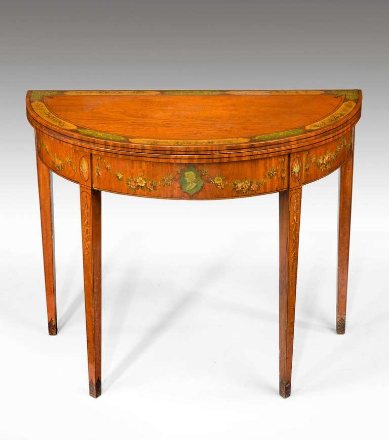 George III period demilune satinwood card table with reserve painted panels, the borders with trailing foliage. Stamped on reverse base, S.& H. JEWELL, 29, 30 & 31, LITTLE QUEEN ST, HOLBORN.W.C.( Retailers).

See also Bonhams 19th June 2012 Large
