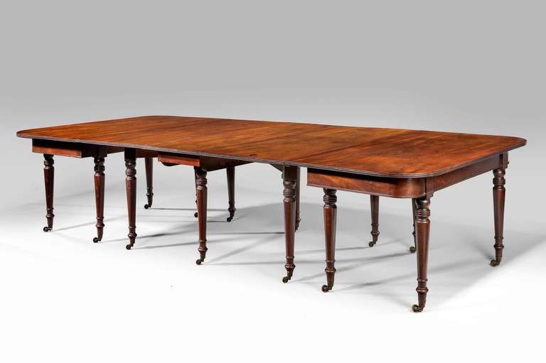 Ascribed to Gillows of Lancaster. A fine extending mahogany early 19th century banqueting table with original leaves on turned supports retaining original shoes and castors. The configuration of the table allows it to seat from six to fourteen