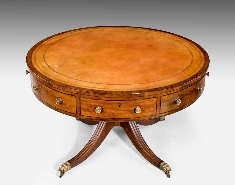 A good Regency period mahogany drum or library table with alternate swing action opening drawers, above the drawers a cross banded top with ebony inlay over a cross banded edge, strongly reeded sabre supports on original shoes and castors. Retain