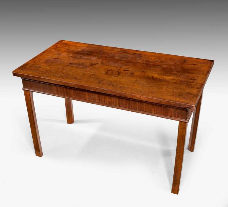 Chippendale period mahogany serving table in a very restrained form, with a cross banded and well figured freeze, the whole on square chamfered supports.
