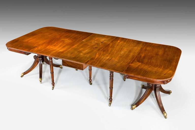 A fine and rare Regency period mahogany three part dining table of wonderful golden color and in entirely original condition, the table can be used for just six persons if required as the drop in centre can be used quite separately or as it's shown