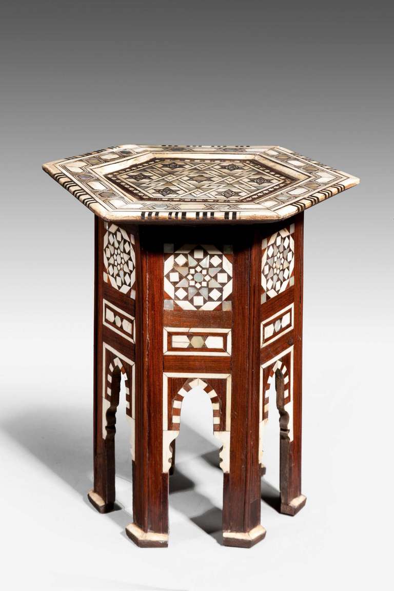 A very pretty hexagonal bone and hardwood centre table of small proportions, profusely inlaid with parquetry decoration to the top of the elaborate checked design, central motif in abalone pearl, the legs terminating with block feet.