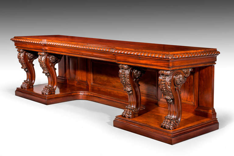 A truly magnificent Regency period inverted breakfront serving table on a raised platform. The continuous carved upper border with acanthus leaves at each terminal over two superbly designed and carved supports, strongly scrolled cabriole design