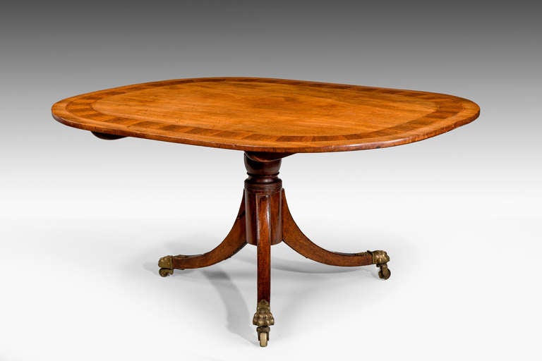 A fine quality George III period mahogany dining table, the top broadly cross-banded in kingwood with boxwood and ebony banding, the turned stem over four swept sabre supports terminating in period shoes and castors.