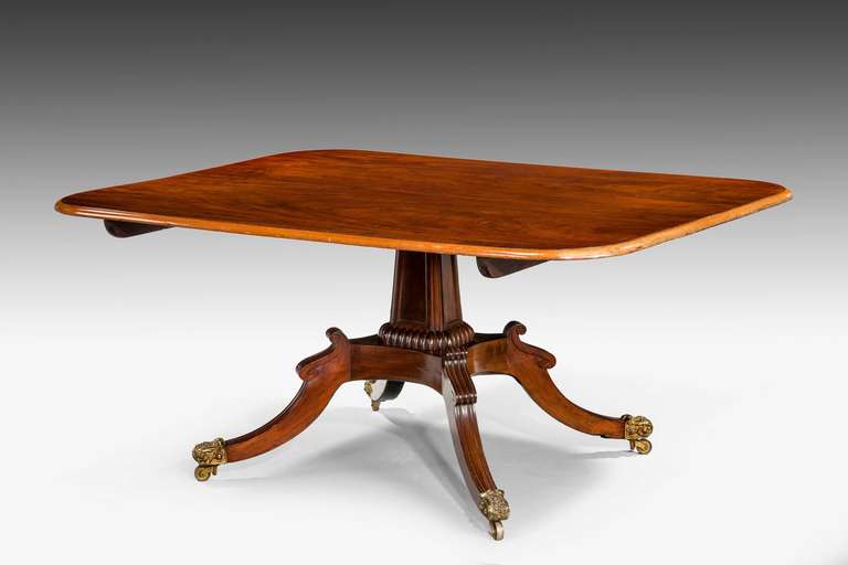 An quite exceptional Regency period mahogany breakfast table, the finely figured top over a rectangular tapering stem with inset flame veneered panels. Hipped sabre supports terminating in quite exceptional shoes and castors.

