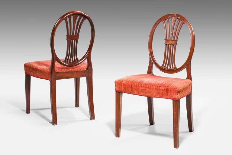 Pair of George III Hepplewhite chairs, the oval backs with well carved Prince of Wales feathers and the center splat with an oval sunburst in satinwood. Chamfered tapering supports.

RR.