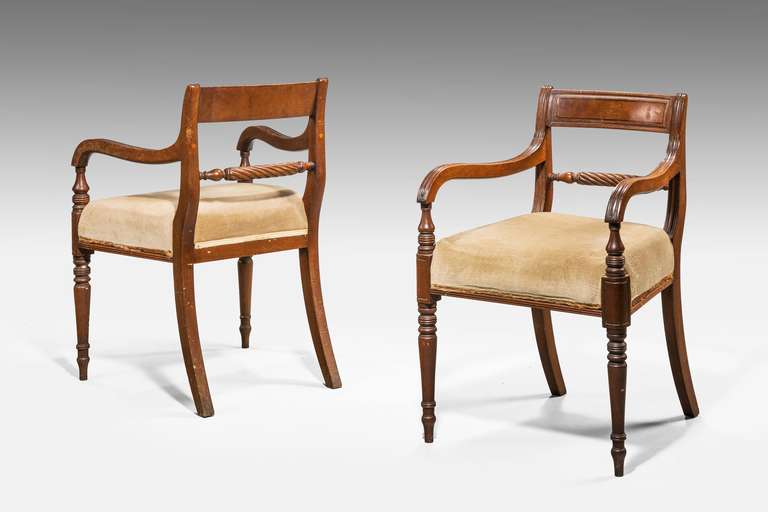 A pair of Regency period mahogany chairs, the centre rail with writhen decoration, well framed supports tapering and with reeded detail.

