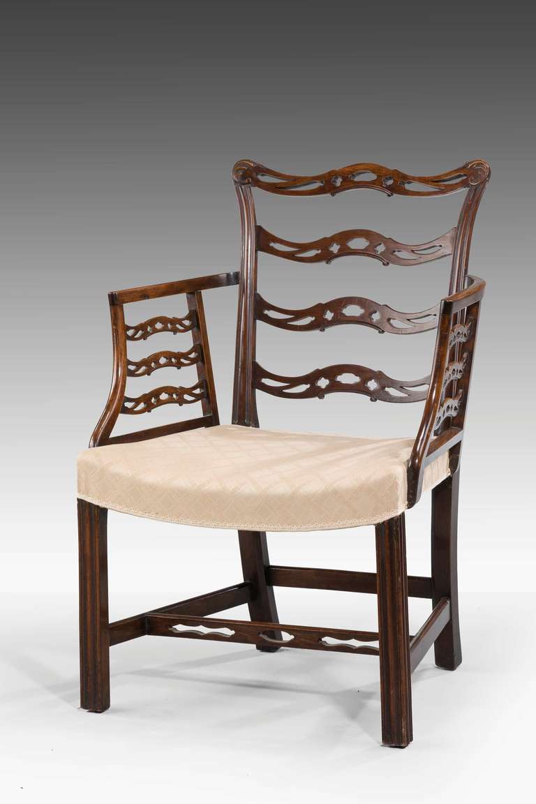 Ellbogenstuhl mit gewellter Rückenlehne aus Mahagoni im Chippendale-Design. Die hinteren Stützen enden in einem geschwungenen Buckel mit durchbrochenen Leisten und Seitenteilen. RR.

 