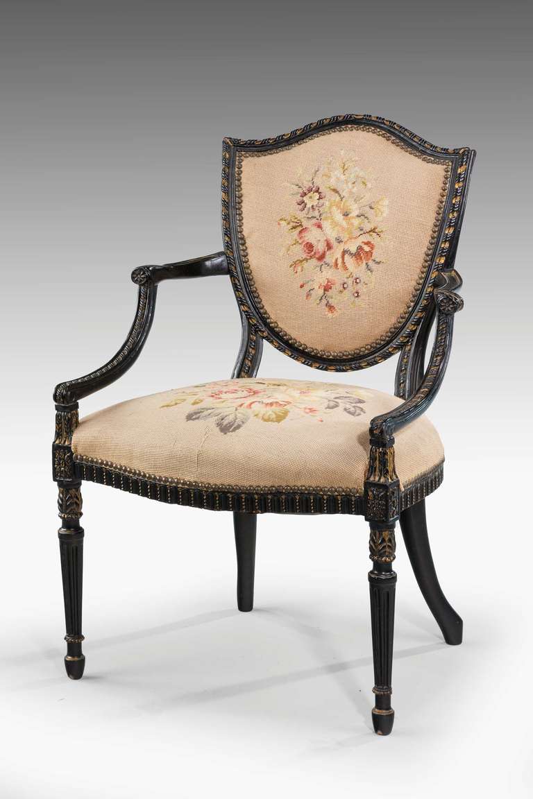 A finely carved Hepplewhite style mahogany elbow chair of very elegant outline, continuously carved border over turned, reeded and cast supports.

RR.