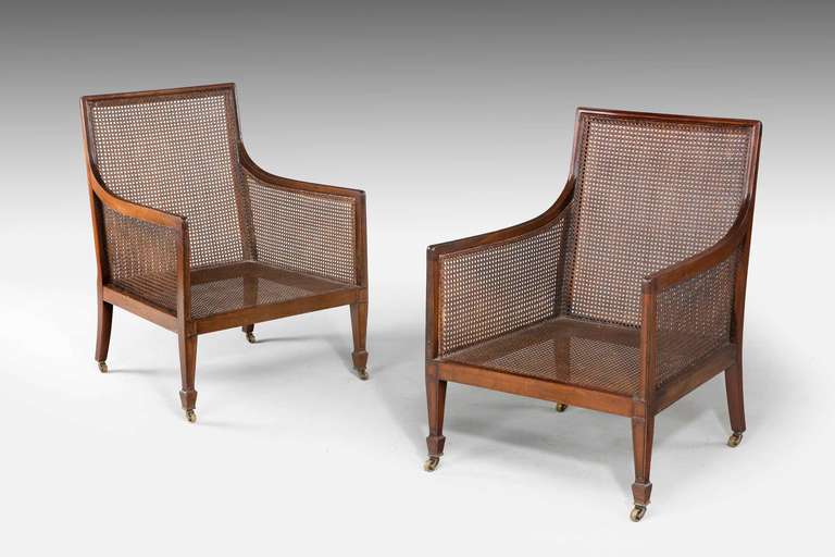 A good pair of Regency style mahogany framed bergere chairs in excellent overall condition, square tapering supports terminating in block feet. Brass plaque reads 
