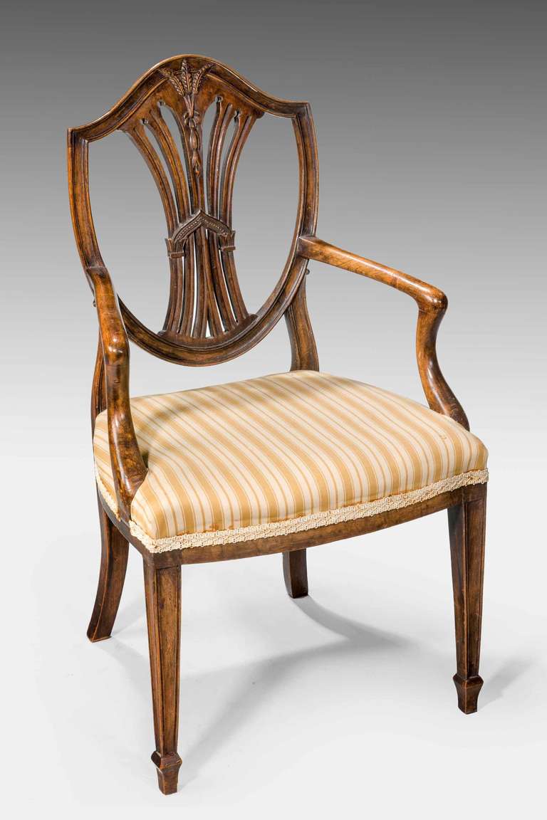 Late 19th century unusual pair of mahogany children’s chairs of Hepplewhite design, the arched top over wheat ear carving, pierced splat on square section supports terminating in spade toes.

