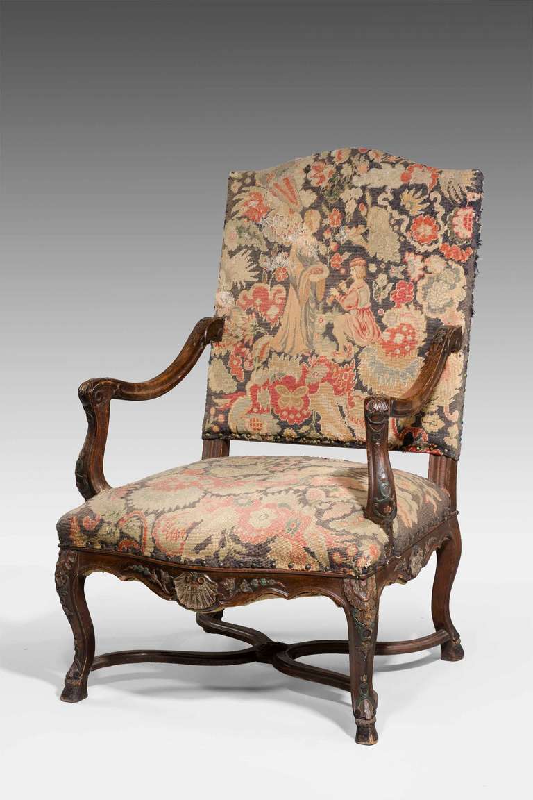 A very well carved 19th century walnut armchair of early 18th century design, the frame with shells and foliage, the supports joined with a shaped stretcher, covered in grosse point now very tired.

