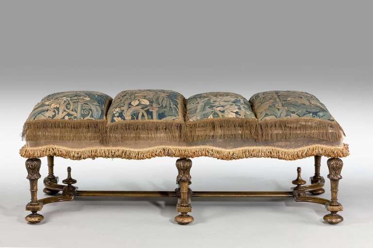 A most unusual stool of James II design in walnut on well carved shaped supports, the upper section with inverted stylised tulips, wavy cross stretchers together with three gross - point mid-19th century cushions, the stool circa 1900.

