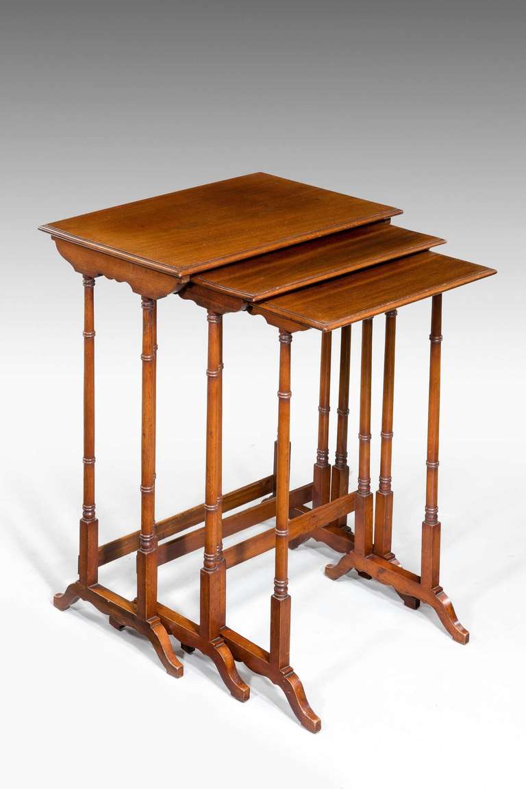 Nest of three Regency period mahogany tables on finely turned supports.