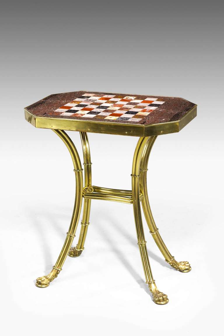 An elegant French gilt bronze chess table with an inset specimen marble top, on triple- cluster supports terminating in well cast paw feet, early 20th century.

