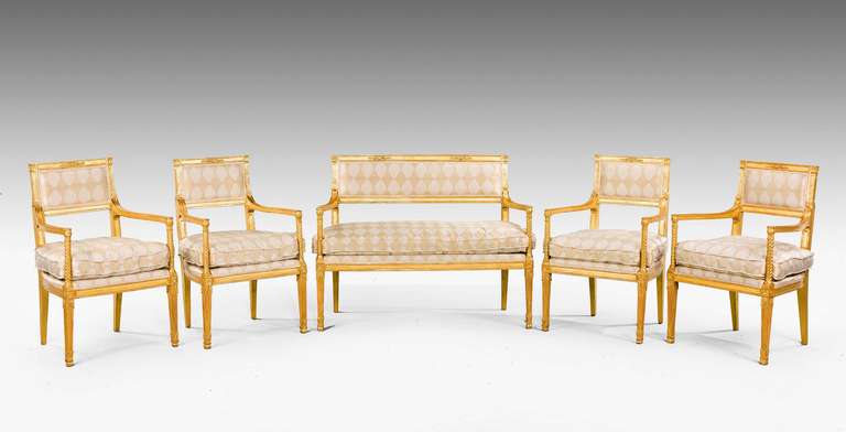 An exceptionally fine late 18th century Italian giltwood salon suite comprising a canapé and four fauteuils, the backs with neoclassical decoration, writhen arm supports and finely carved reeded legs.
