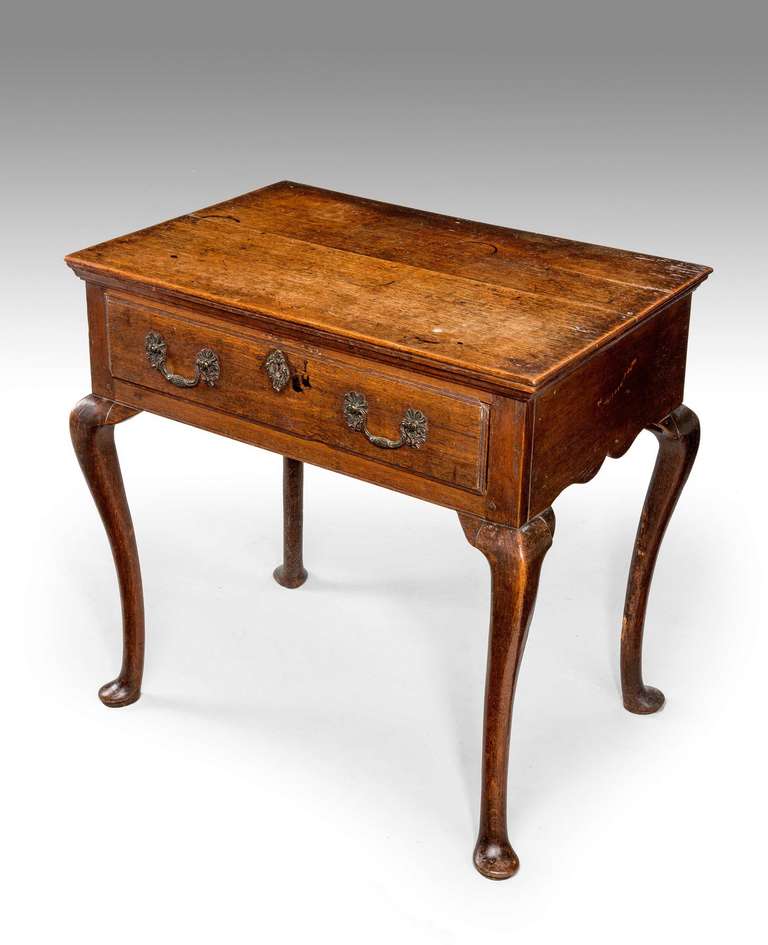 An attractive oak side table or lowboy, the single drawer to the freeze with Rococo gilt bronze swan neck handles, elegant cabriole supports terminating in pad feet.

