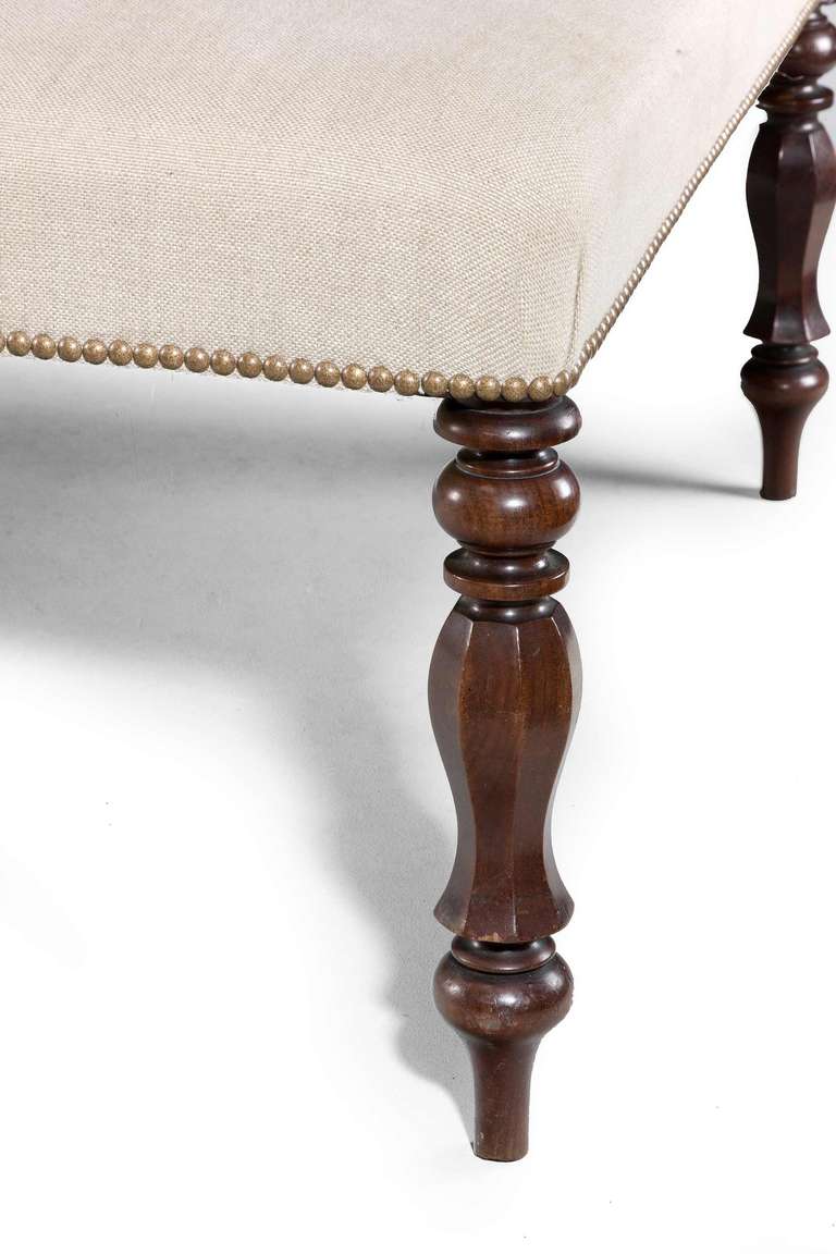 Large mahogany upholstered stool on octagonal faceted supports, mid-20th century.


