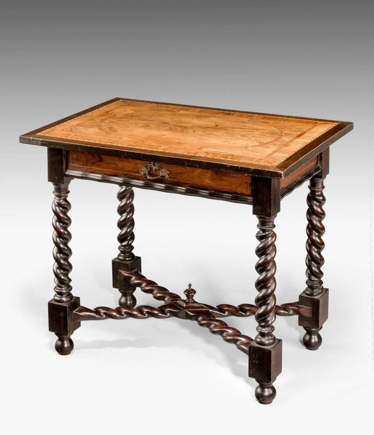 An early 18th-century Portuguese Side Table of good substantial construction, the writhen supports well carved with a matching cross stretcher with a finial to the centre, the top in olive wood with inlaid stringing and cross banding.