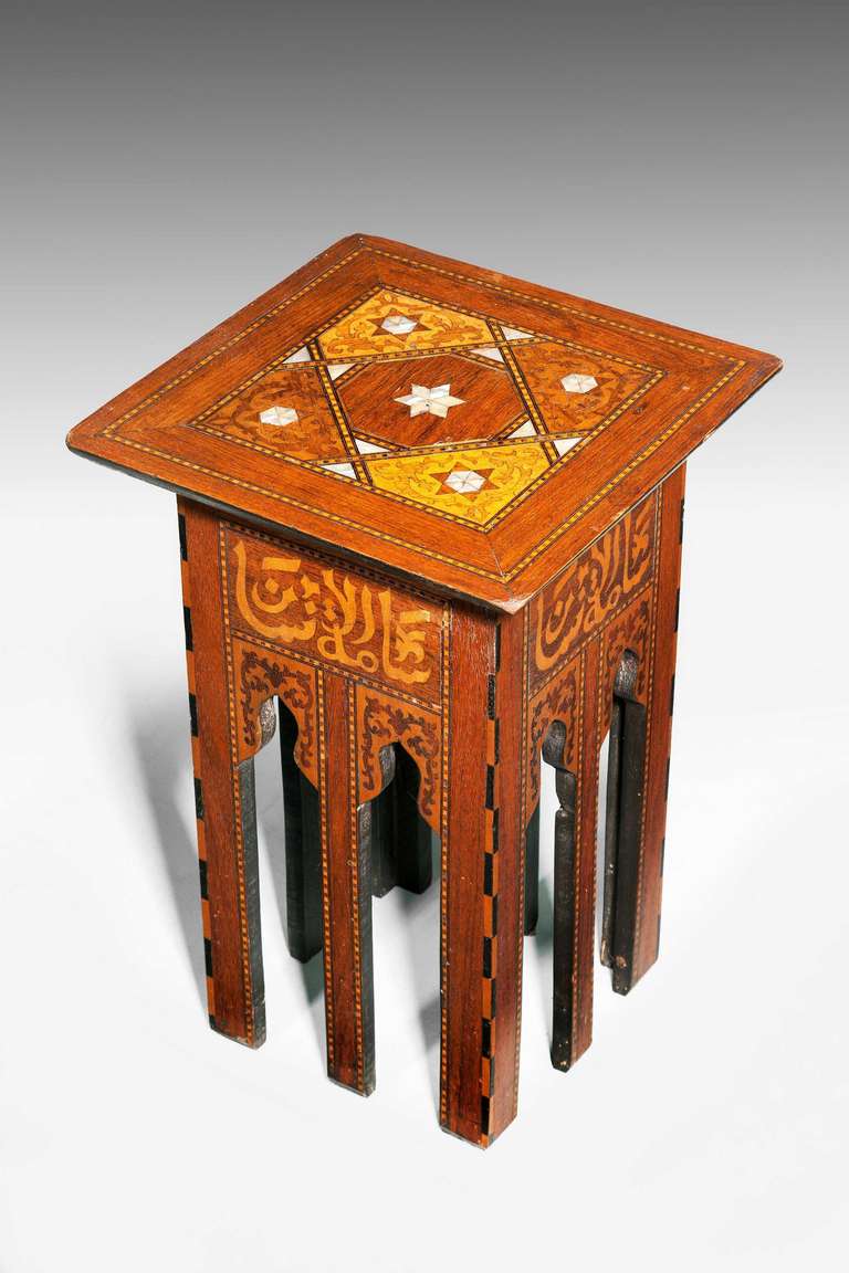 Islamic occasional table on eight square section supports, the border with 'Kufic' inscription with words from the Quran, the top section with abalone pearl decoration, elaborate corner sections with marquetry and cross grain veneers.


