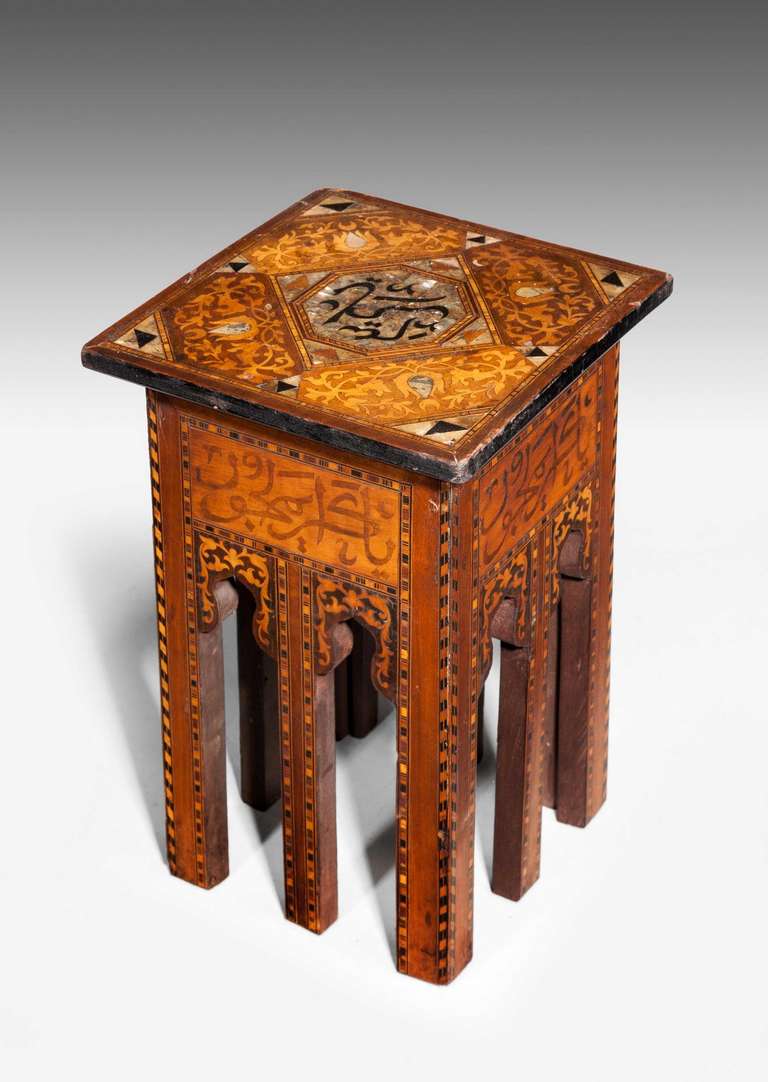 A good Eastern hardwood table, the eight supports of the square section and the corners of table all with alternate inlays of ebony and boxwood, the central top with insignia from the Quran with stylized panels with inlaid tulips and mother of