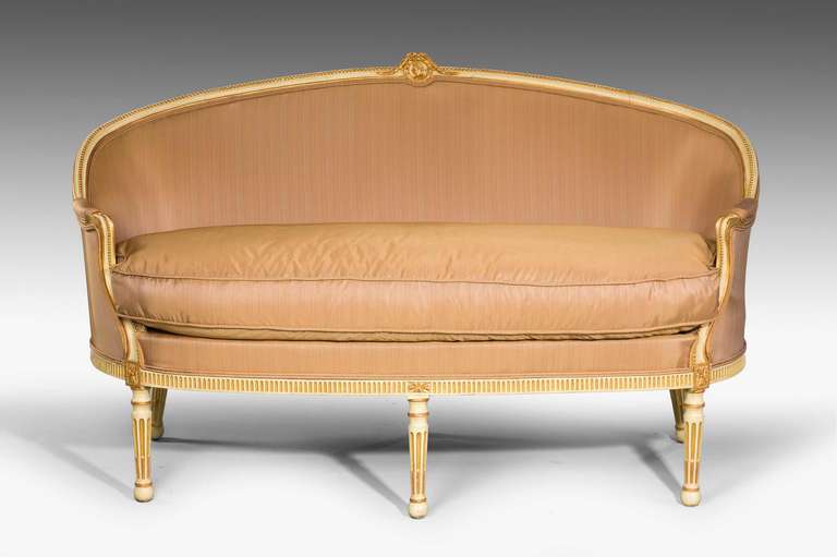 A Louis XVI period parcel-gilt Canapé, the frame with incised and continuous beadwork decoration, the upper top with a laurel leaf appliqué containing a neoclassic bust.

