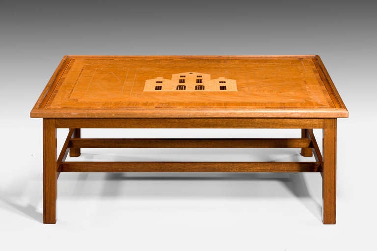 A most unusual mahogany low table, the top with complex herringbone and crossbanded decoration, the centre inlaid with a design for a late Georgian house.

