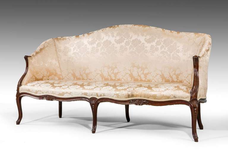 George III period mahogany frame sofa in the 'French' taste, the swept arm supports with incised carving, serpentine front and side rails with foliage and scroll detail. The supports with graduated harebells. Smaller sofa also available.

