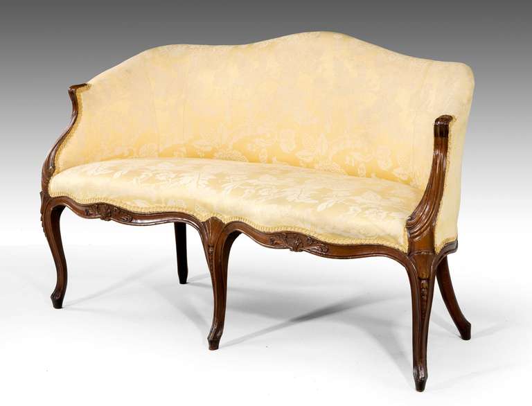 George III period mahogany frame sofa in the 'French' taste, the swept arm supports with incised carving, serpentine front and side rails with foliage and scroll detail. The supports with graduated harebells. 

